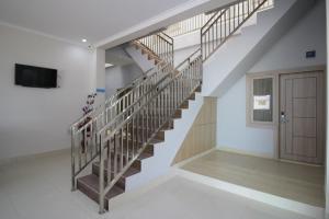 a spiral staircase in a house with a door at RedDoorz near Jalan Kolonel Haji Burlian Palembang in Palembang