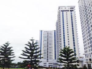 two tall buildings with trees in front of them at Hannah's Place at Wind Residences in Tagaytay