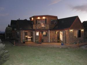 a large brick house with a balcony at night at First Light Kaikoura in Kaikoura