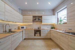 a large kitchen with white cabinets and a window at Willa Wrzos in Zakopane