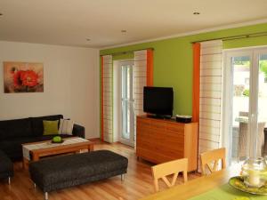 a living room with a couch and a tv at Ferienhof Nirschl in Winzer