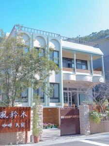 une grande maison avec une clôture devant elle dans l'établissement Nanchuang Wind Suzuki Coffee Houses, à Nanzhuang