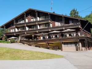 ein großes Gebäude mit Tischen und Sonnenschirmen in der Unterkunft Hotel-Restaurant Jägerhof in Unterreichenbach