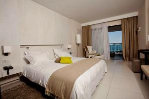 a bedroom with a large white bed with a yellow pillow at Dar El Marsa Hotel & Spa in La Marsa
