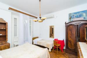 ドゥブロヴニクにあるRooms Ivo 1のベッドルーム1室(ベッド2台、テーブル、椅子付)