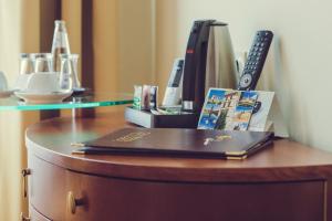 a desk with a book and a remote control on it at Hotel Arena City in Leipzig