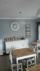 a kitchen with a table and a clock on the wall at Garden Gate Guest House in Port Elizabeth