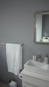 a white bathroom with a sink and a mirror at Garden Gate Guest House in Port Elizabeth +28 photos