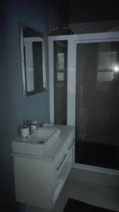 a white bathroom with a sink and a shower at Garden Gate Guest House in Port Elizabeth