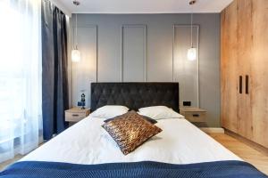 sypialnia z łóżkiem z poduszką geparda w obiekcie Angielska Grobla Apartinfo Apartments w Gdańsku