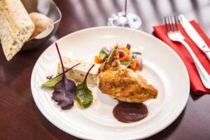 een witte plaat met eten op tafel bij Mercure Paris Roissy CDG in Roissy-en-France