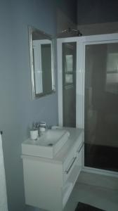 a white bathroom with a sink and a shower at Garden Gate Guest House in Port Elizabeth
