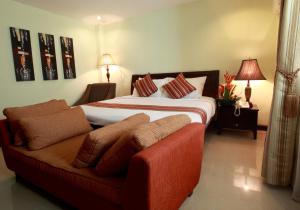 1 dormitorio con 1 cama grande y 1 sofá en The Suites at Calle Nueva, en Bacolod