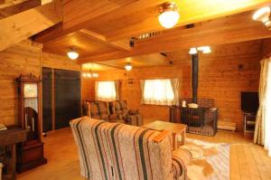 a living room in a log cabin with a fireplace at Log Cottage Epoch in Hakuba