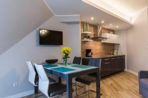 a kitchen and dining room with a blue table and chairs at udanypobyt Apartamenty Orkana Park Centrum in Zakopane