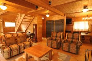 ein Wohnzimmer mit 2 Sofas und einem Tisch in der Unterkunft Log Cottage Epoch in Hakuba