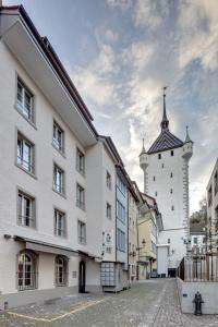 a white building with a tower and a church at smartroom The Residence la Cittadella Baden in Baden