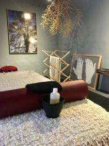 a bedroom with a bed and two pairs of feet on a rug at "Chambre d'Autres", massages in Montpellier