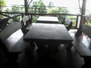 a wooden table and chairs on a porch at Bang Son Golden View in Baan Khai
