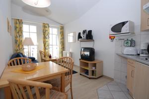 una cucina e una sala da pranzo con tavolo e TV di Seepark Sellin - Apt. 449 a Ostseebad Sellin