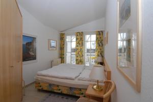 オストゼーバート・ゼリンにあるSeepark Sellin - Apt. 449のベッドルーム1室(黄色いカーテンとランプ付きのベッド1台付)