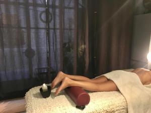 a woman in a dress laying on a bed with a candle at "Chambre d'Autres", massages in Montpellier