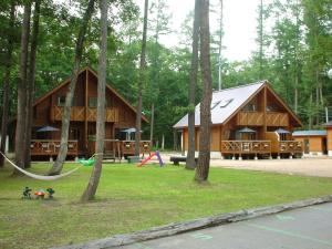 a log cabin with a hammock and a playground at Log Cottage Epoch in Hakuba