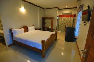 a bedroom with a large bed with white sheets at Suksopha Resort in Prachuap Khiri Khan