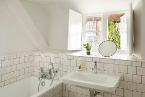 een witte badkamer met een wastafel en een spiegel bij Compasses Inn in Tisbury