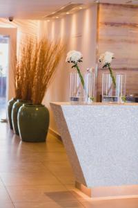 a counter with vases with white flowers in them at Napa Plaza Hotel (Adults Only) in Ayia Napa