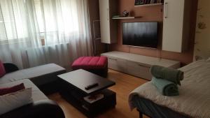 a living room with a tv and a couch and chairs at Sfanta Ecaterina - Garsoniera Alba Iulia in Alba Iulia