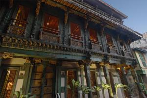 an old building with a balcony on a street at Mangaldas Ni Haveli I by The House of MG in Ahmedabad