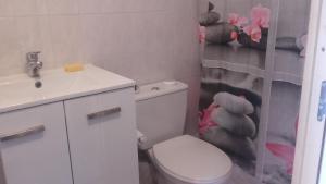 a bathroom with a toilet and a sink and a teddy bear shower curtain at L'oiseau bleu in Salin-de-Giraud