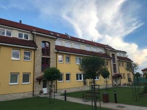 a large yellow building with a lot of windows at Prestige apartment in Komárno