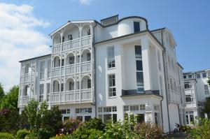 Großes weißes Gebäude mit Balkon in der Unterkunft Seepark Sellin - Apt. 635 in Ostseebad Sellin