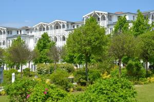 ein großes weißes Gebäude mit einem Garten davor in der Unterkunft Seepark Sellin - Apt. 635 in Ostseebad Sellin