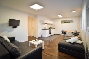 a living room with a couch and a table at Deluxe Ferienwohnung Apartment Stuttgart Centre/Milaneo in Stuttgart