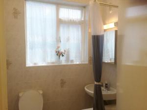 a bathroom with a toilet and a sink and a window at Spacious West London 2 Bedroom Apartment in London +46 photos