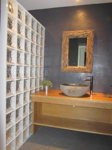 un bagno con lavandino e specchio di Les GITES DE CAMPARAN - gîte "le GRAND CHALET AVEC SPA ET SAUNA" a Camparan Altre 29 foto