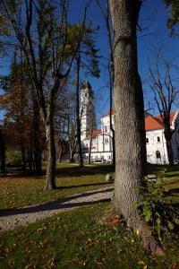 a white building with a tower in a park with trees at Saint Ignatius Retreat House in Ljubljana