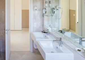 a bathroom with two sinks and a mirror at Hotel Ascona in Ascona