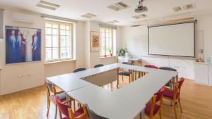 a meeting room with a white board and a projector screen at Saint Ignatius Retreat House in Ljubljana