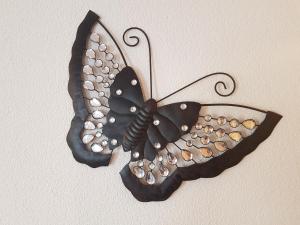 a black butterfly wall decoration on a wall at Chalet Ramona in Grächen