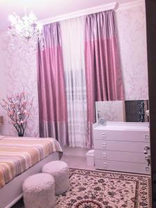 Dormitorio rosa con cama y tocador en apartamenti drevni batumi, en Batumi