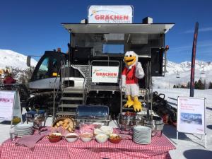 a table with food on it with a mascot in front of a truck at Chalet Ramona in Grächen