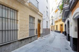 un callejón vacío en una ciudad con edificios en Dulce Arbolí Little Apartments, en Cádiz