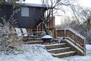 a house with a fence and stairs in the snow at Cherry Tree Gypsy Wagon Sibford Gower in Banbury
