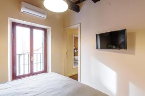 ローマにあるTrans Tiberimのベッドルーム1室(ベッド1台、壁掛けテレビ付)