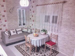 comedor con mesa, sillas y sofá en apartamenti drevni batumi, en Batumi