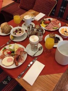 - une table avec des assiettes de produits pour le petit-déjeuner et des boissons dans l'établissement Hotel zum Heiligen Geist, à Mariazell